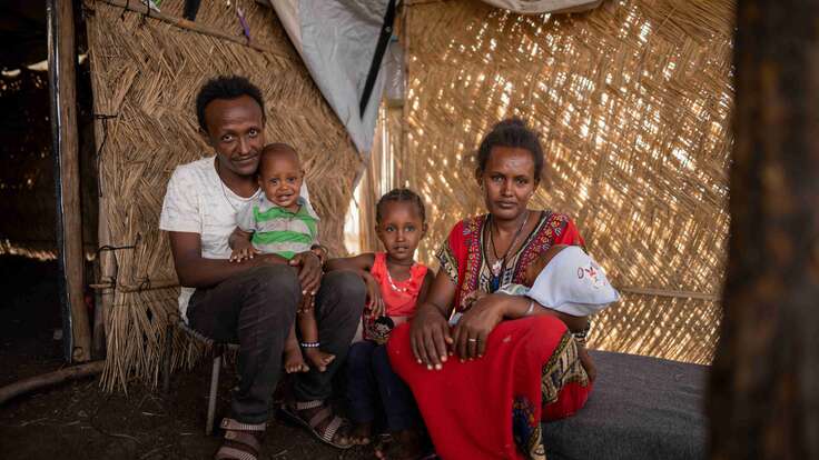 Almas, 33, sits with her family inside their tent in the Tunaydbah camp, located in Eastern Sudan.